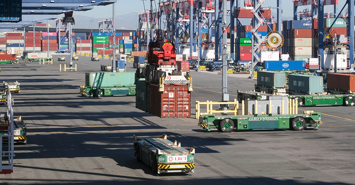 Computer-controlled cargo cranes rapidly lift containers from ships to zero emission Automated Guide Vehicles at the Long Beach Container Terminal. Image: Ringo Chiu / Shutterstock
